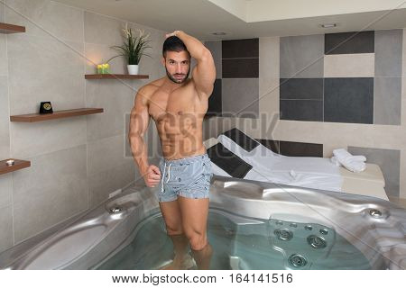 Man Flexing Muscles In Jacuzzi Spa