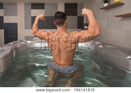 Guy Flexing Muscles In Azure Jacuzzi