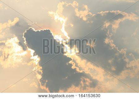 Cloudy sky background, bright sunbeams through dark clouds, message from God, overcast autumn weather