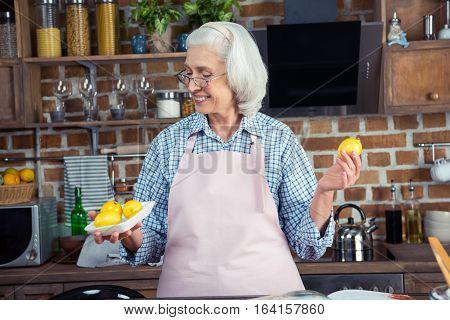 Woman Looking At Lemons In Kitchen