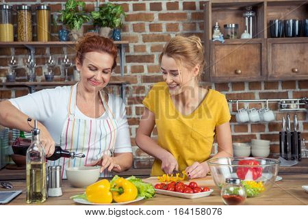 Mother and daughter cooking vegetable salad together