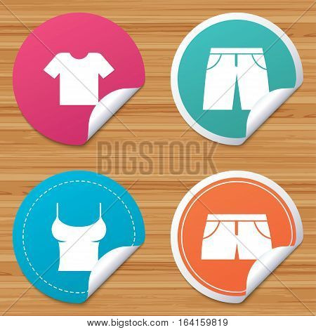 Round stickers or website banners. Clothes icons. T-shirt and pants with shorts signs. Swimming trunks symbol. Circle badges with bended corner. Vector