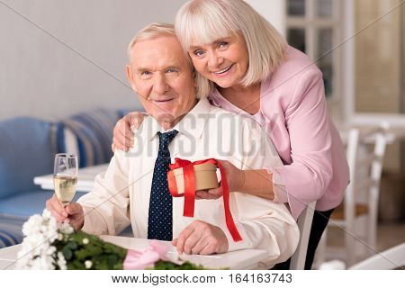 What could be better. Precious happy elderly couple posing for a picture capturing one of the best moment of their lives during their anniversary celebration in a restaurant