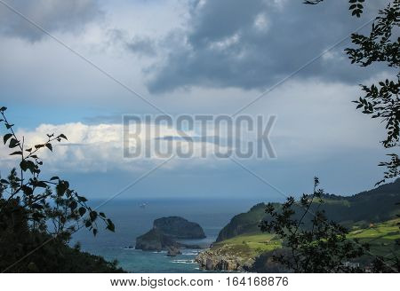 Gastelugache -  island on  coast of  Bay of Biscay belonging to  municipality of Bermeo, Basque Country.  Island is connected to  mainland by  man-made bridge that goes into  winding staircase that spans 237 degrees.