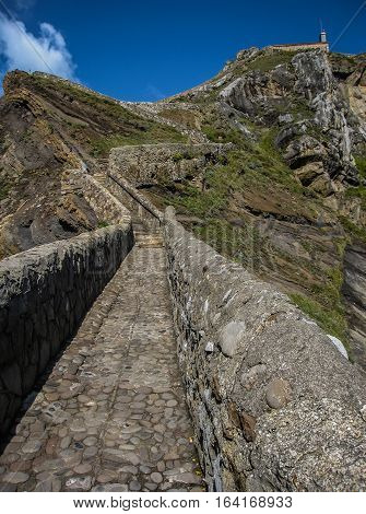 Gastelugache -  island on  coast of  Bay of Biscay belonging to  municipality of Bermeo, Basque Country.  Island is connected to  mainland by  man-made bridge that goes into  winding staircase that spans 237 degrees.