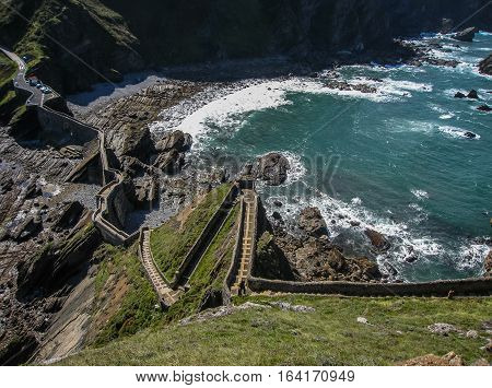 Gastelugache -  island on  coast of  Bay of Biscay belonging to  municipality of Bermeo, Basque Country.  Island is connected to  mainland by  man-made bridge that goes into  winding staircase that spans 237 degrees.