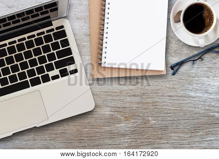 flat lay top view of laptop computercup of coffee and notepad on office desk with copy sapace
