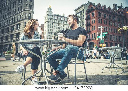 Couple dating in a coffeehouse bar in Manhattan - Tourists talking and having fun while sighseeing New York