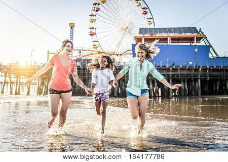 Lesbians mothers with adopted child - Happy homosexual family playing with her daughter