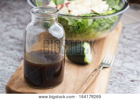 A Glass Bottle With Salad Dressing Consisting Of Balsamic Vinegar, Honey And Olive Oil