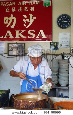PENANG MALAYSIA-29 DECEMBER 2016: Hawker vendor at their Assam Laksa noodle stall in Air Itam Penang Malaysia. Assam Laksa is ranked 7th most delicious food in the world by CNN.