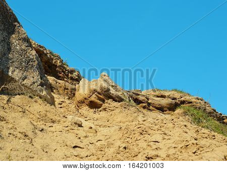 Rocky slope with the trodden sand road