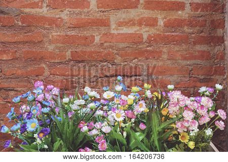 Flower pot in front of a brick wall in the garden. Filtered image processed vintage effect.
