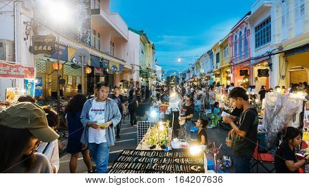 PHUKET THAILAND NOVEMBER 27: Tourists enjoy shopping at the walking street among old building Chino Portuguese style on street of Phuket town Thailand on November 27 2016.