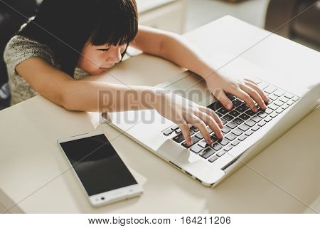 Cute asian little girl using laptop at home . Seleted focus.