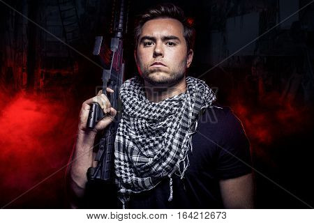 Soldier with a gun surviving in the smoky ruins of an urban warzone on fire. The military contractor or PMC is a hired militia during war.