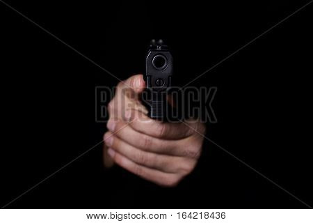 Closeup view of man's hands aiming with gun.