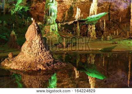 Cave with many stalagmites and stalactites in Punkevni cave czech republic. Mirroring the interior of the cave in the lake