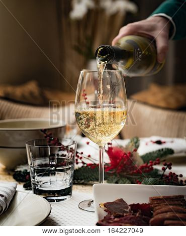 Man pours white wine into a glass