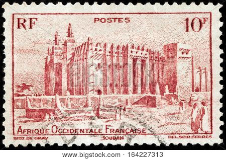 LUGA RUSSIA - NOVEMBER 29 2016: A stamp printed by FRENCH WEST AFRICA shows view of Great Mosque of Djenne. Mosque is located in the city of Djenne on flood plain of Bani River circa 1947