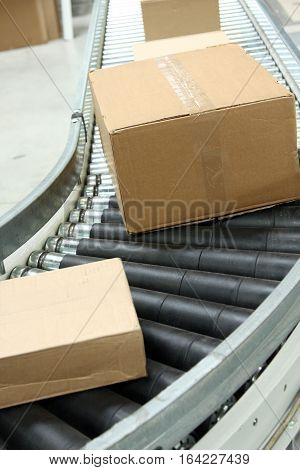 Boxes on conveyor belt in logistics distribution warehouse.