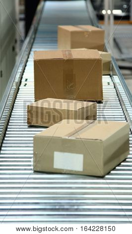 Boxes on conveyor belt in logistics distribution warehouse.