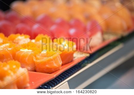 row of group of salmon maki roll sushi with copy space
