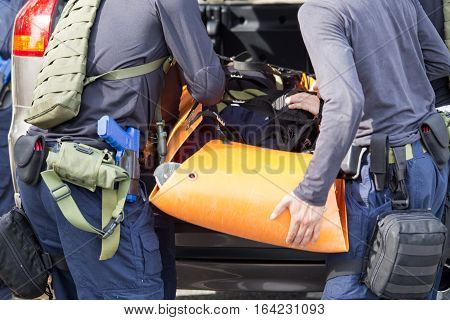 law enforcement team use light stretcher for medical evacuation to vehicle in training course
