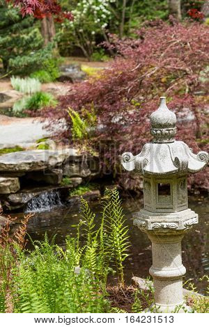 Stone sculpture in a lush green japanese garden