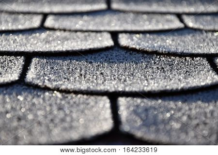 Roof with asphalt shingles is frostbitten. Frost.