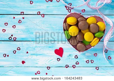 Frame Valentine's Day Or A Birthday, Mother's Day. Gifts Makarons Cake With Heart On A Blue Wooden B