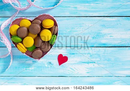 Frame Valentine's Day Or A Birthday, Mother's Day. Gifts Makarons Cake With Heart On A Blue Wooden B