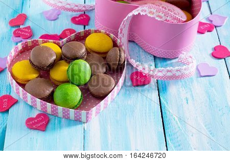 Frame Valentine's Day Or A Birthday, Mother's Day. Gifts Makarons Cake With Heart On A Blue Wooden B
