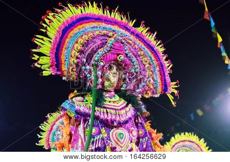 BAMNIA PURULIA WEST BENGAL INDIA - DECEMBER 23RD 2015 : Dancer performing at Chhau Dance festival. It is a Indian tribal martial dance at night based on Hindu myth. Shot under colored light.