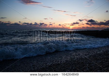 the sun sets over the sea horizon