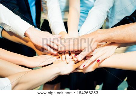 Large business team holding their hands together.
