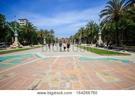 Barcelona, Spain - May 27, 2016: many tourists near the Arc de Triomphe in sunny summer day, city map on the ground
