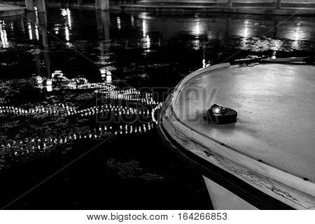Bow of a boat in the water with Christmas light relfection.