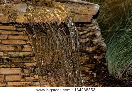 Closeup of water flowing over rock fountain.