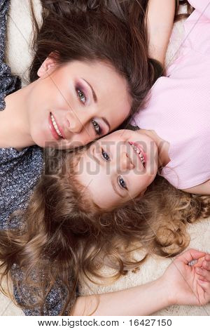 Muotokuva äiti ja curly tyttö makaa lähellä toisiaan