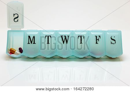 A pill box with Sunday's pills visible.