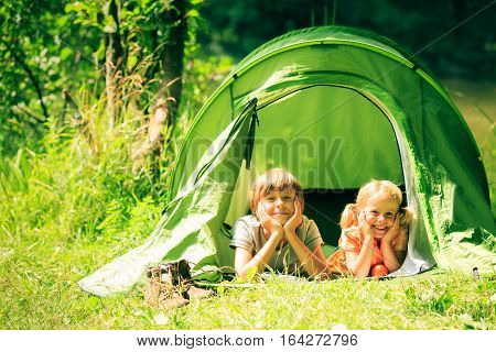 brother and sister are lying inside their tent