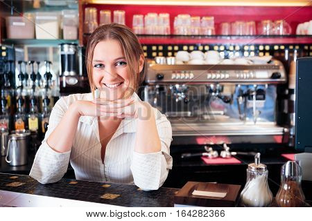 friendly bartender at a cafe, smiling at camera.