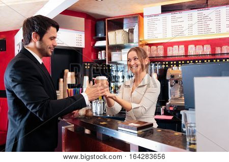friendly bartender at a cafe, serving coffee-to-go to a customer