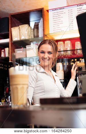 friendly bartender at a cafe, smiling at camera.