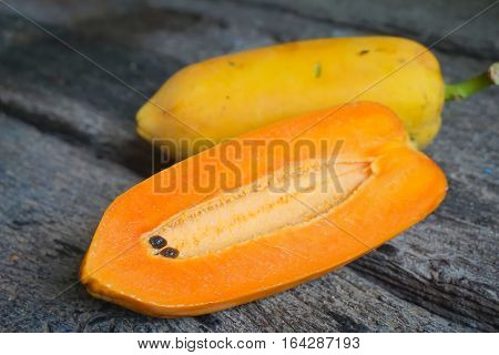 Papaya fruits are placed on the floor plates, old wood.