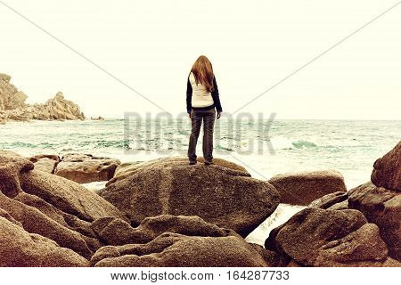 Girl standing on rock. Woman suffering from fear loneliness depression abuse addiction