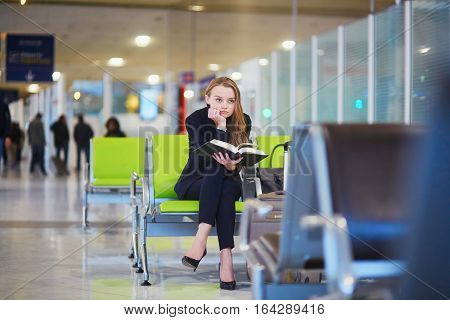 Woman In International Airport Terminal, Reading Book
