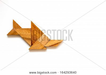 Wooden tangram as sawfish shape on white background