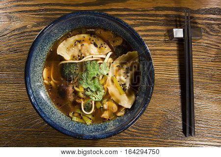 Gedza soup in a ceramic pot on a wooden table